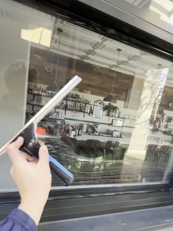 After: The same storefront glass after cleaning, with the restaurant's bar and dining room clearly visible, commercial exterior cleaning on the Central Coast