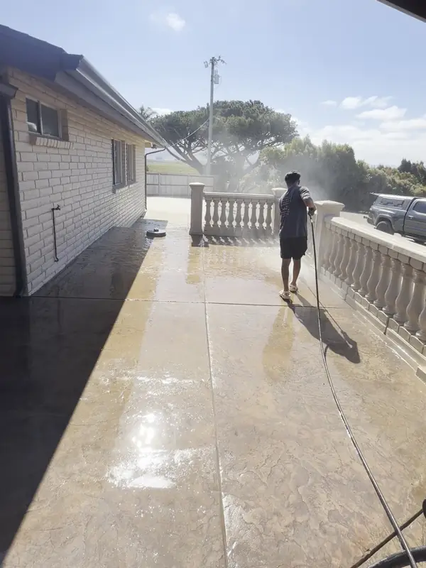 After: The same stamped concrete patio after High Tide pressure washing, clean and still wet from the rinse