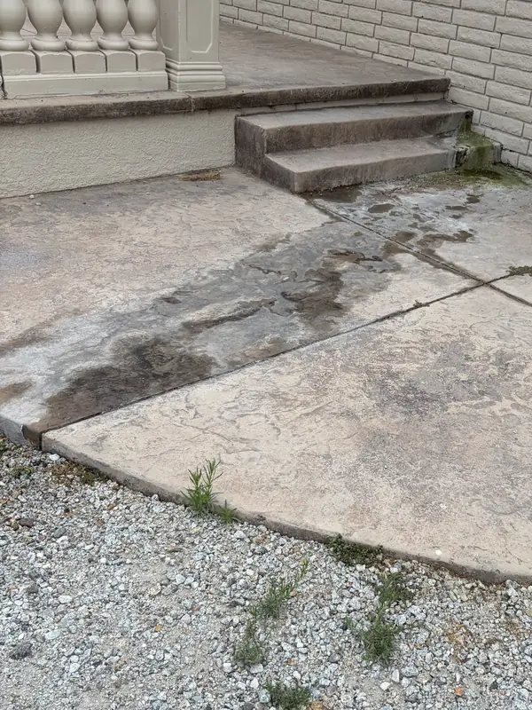 Before: Stamped concrete patio and steps darkened by grime and water stains before pressure washing